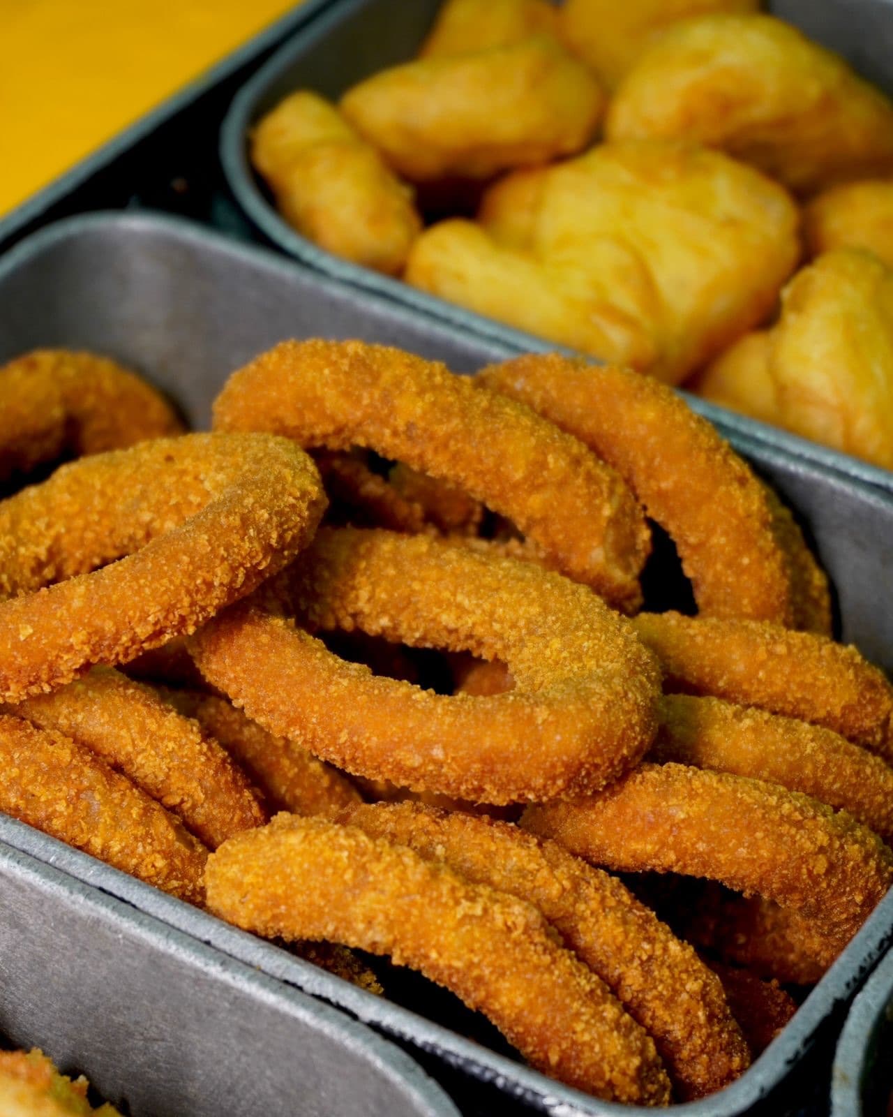 Anéis de cebola e mandioca frita nas cubas de inox